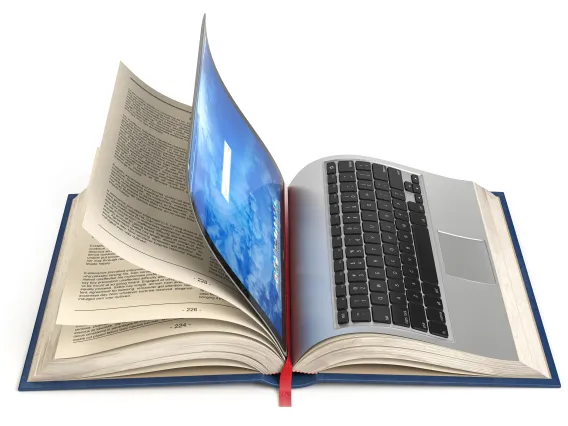 A laptop on top of an open book